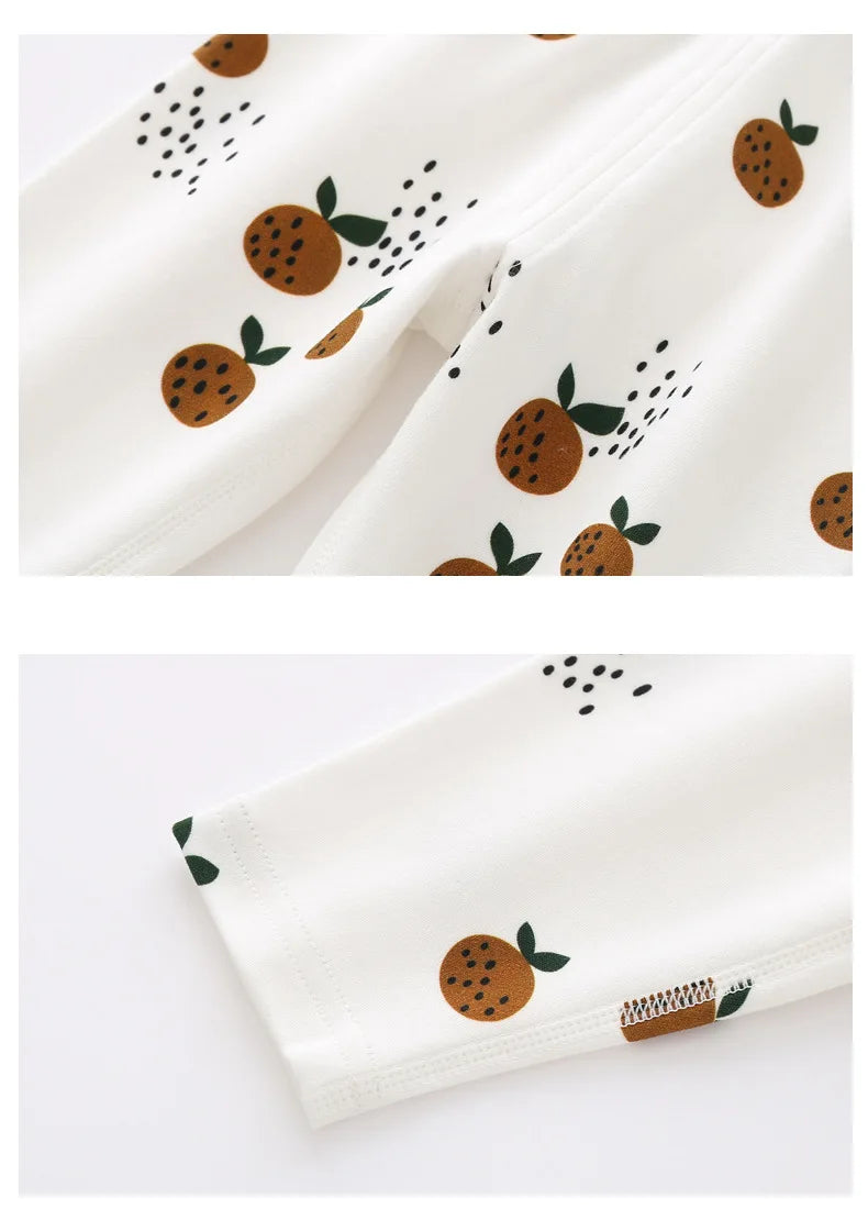 Close-up van biologisch katoenen baby legging met elastische tailleband en oranje fruitprint