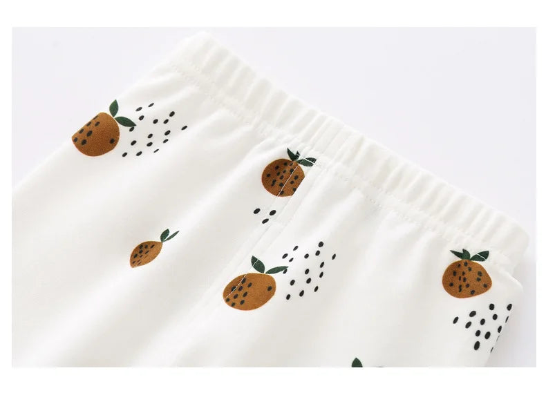 Detail van baby legging van biologisch katoen met elastische tailleband en fruitige print in oranje tinten